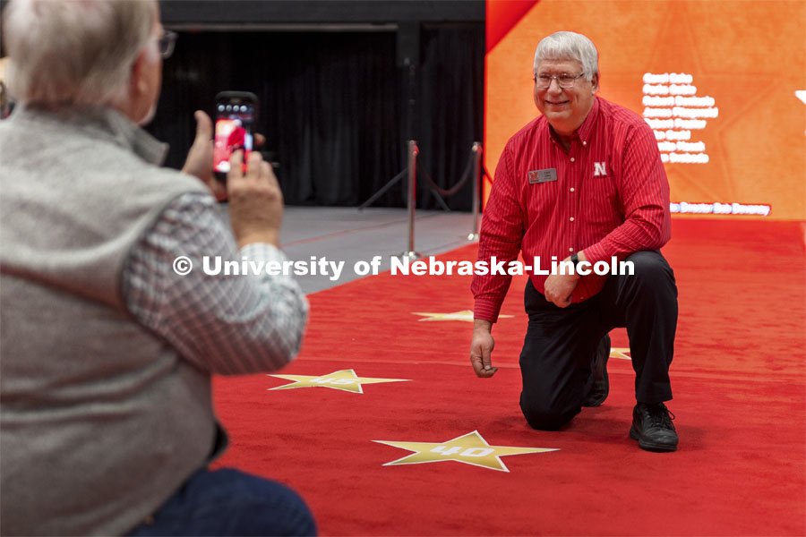 Paul Jasa, a 40-year Extension Engineer with Biological Systems Engineering, has his moment on the walk of fame as he gets his photo taken with his star. Salute to Service gathering in the Coliseum. November 18, 2021. Photo by Craig Chandler / University Communication.