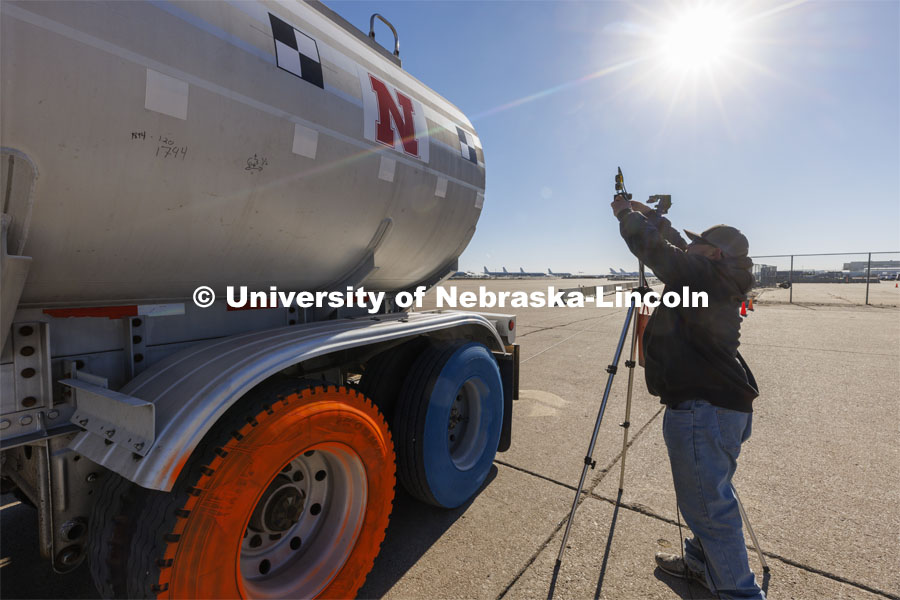 Dave Charrion checks a camera alignment used for a speed check before the tanker was driven back to its starting point. Researchers from the Midwest Roadside Safety Facility conducted a rare tractor-tanker crash to test how a newly designed and significantly less tall concrete roadside barrier performs in a crash. The test was at the facility’s Outdoor Proving Grounds on the western edge of the Lincoln Municipal Airport. December 8, 2021. Photo by Craig Chandler / University Communication.