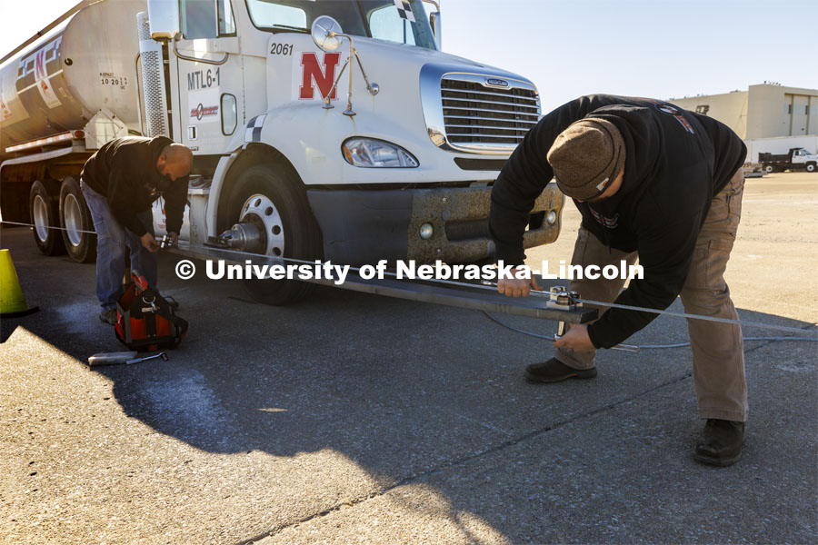 A steering guide which rides along a second cable and keeps the wheels straight is connected before the test. Researchers from the Midwest Roadside Safety Facility conducted a rare tractor-tanker crash to test how a newly designed and significantly less tall concrete roadside barrier performs in a crash. The test was at the facility’s Outdoor Proving Grounds on the western edge of the Lincoln Municipal Airport. December 8, 2021. Photo by Craig Chandler / University Communication.