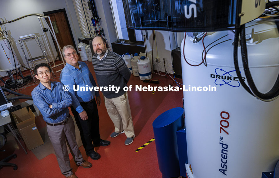 CIBC Directors Jiantao Guo, Robert Powers and Jean-Jack Riethoven pose with the Nuclear Magnetic Resonance spectroscope in Hamilton Hall. Support for Nebraska’s Center for Integrated Biomolecular Communication has been renewed for five more years, as the center continues to position the university as a national leader in the critical area of biomedical research.CIBC was created in 2016 as a National Institutes of Health Center of Biomedical Research Excellence, or COBRE. A nearly $10.7 million Phase 2 grant will fund the center through 2026.The center is focused on investigating cellular level miscommunications that contribute to diseases such as cancer, diabetes and chronic liver disease. It fosters a systems approach, combining the research expertise of chemists, biochemists, engineers and bioinformaticists and connects researchers developing new molecular probes and analytical techniques with those unraveling molecular mechanisms of diseases. December 9, 2021. Photo by Craig Chandler / University Communication.
