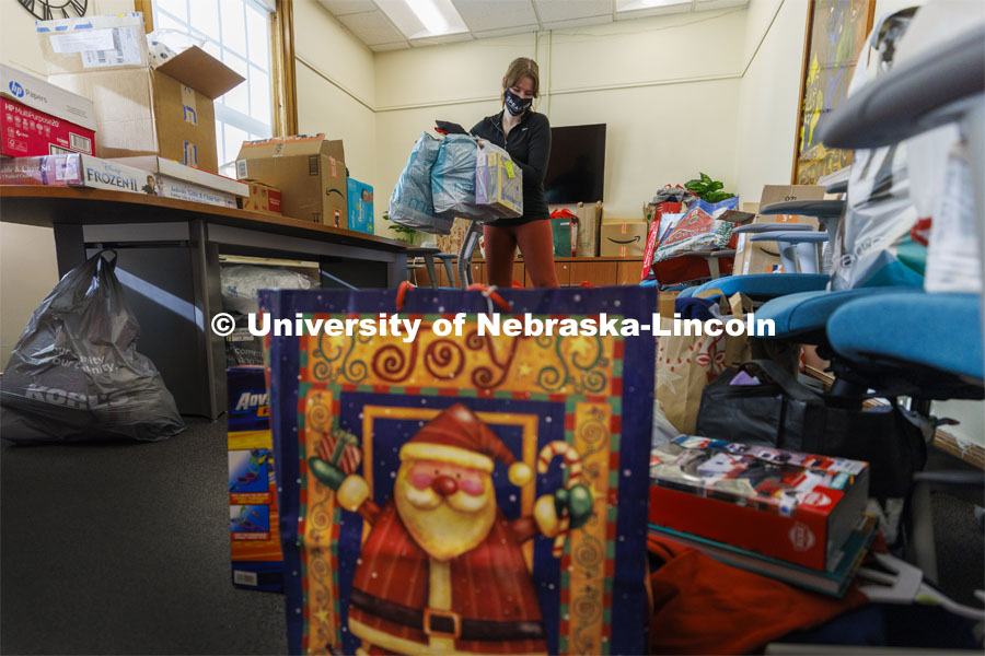 Ashton Koch, senior from Omaha and the outreach coordinator for the Women’s Center, sorts gifts for the Holiday for Little Huskers donation drive. Donations have filled almost every available space in the center. December 9, 2021. Photo by Craig Chandler / University Communication.
