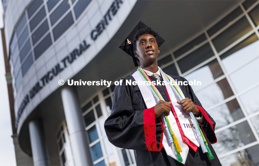 Khalid Yusuf, who served as a Diversity Ambassador, stands in his graduation regalia near the Gaughan Multicultural Center. He is graduating this December with a degree in Psychology. December 14, 2021. Photo by Craig Chandler / University Communication.
