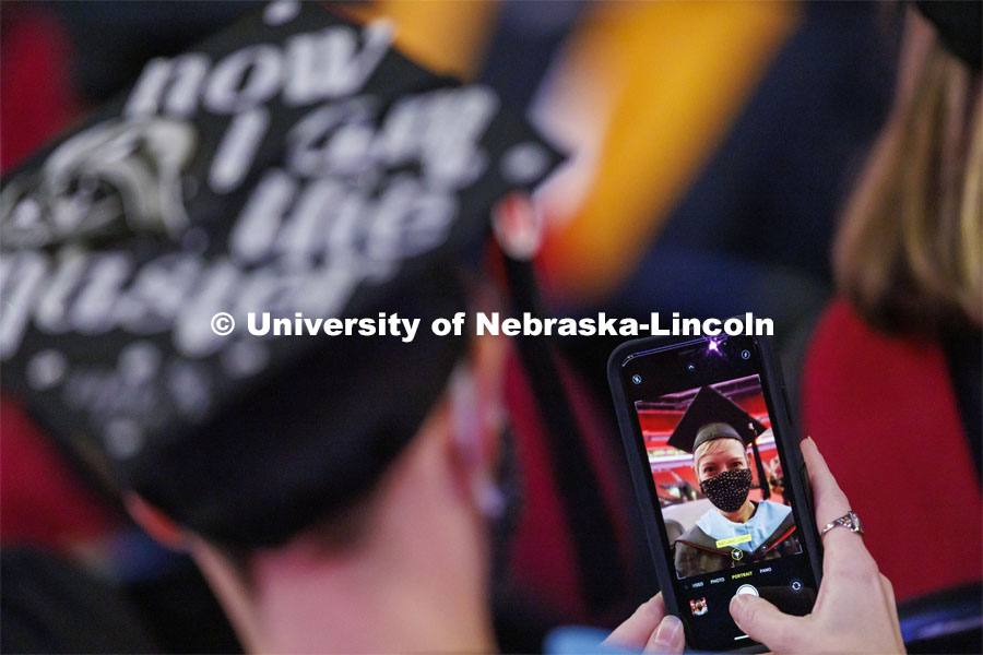 Dara Peters takes a selfie of herself during commencement. Graduate Commencement at Pinnacle Bank Arena. December 17, 2021. Photo by Craig Chandler / University Communication.