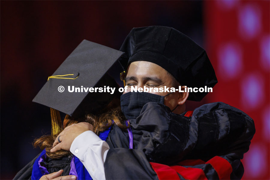 Tyler Kozisek hugs his advising professor Angela Pannier after he was hooded at the Graduate Commencement at Pinnacle Bank Arena. December 17, 2021. Photo by Craig Chandler / University Communication.
