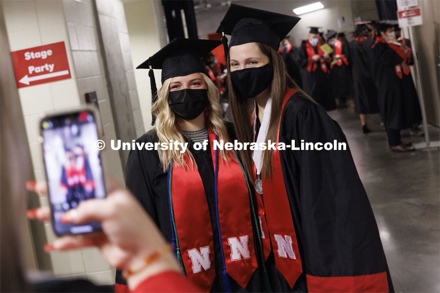 Kaylee Radicia and Lauren von Freiberg are photographed by a friend before the ceremony. Undergraduate Commencement at Pinnacle Bank Arena. December 18, 2021. Photo by Craig Chandler / University Communication.
