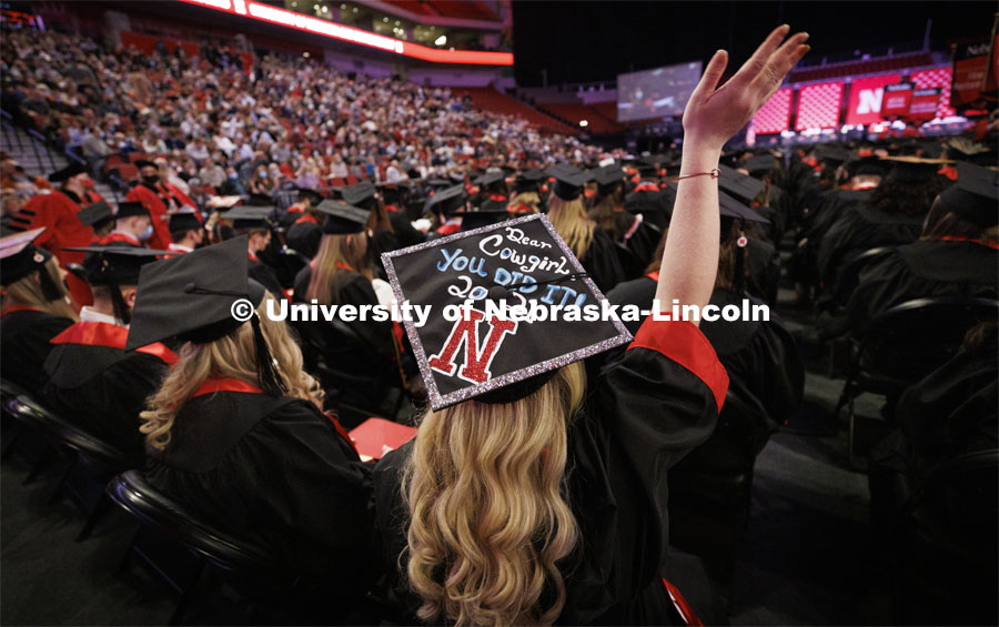 Alyssa Waits waves to her family and friends. Decorated mortarboard. Undergraduate Commencement at Pinnacle Bank Arena. December 18, 2021. Photo by Craig Chandler / University Communication.