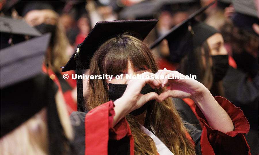 Kellie Roth sends love to her family during the ceremony by making a heart shape with her hands. Undergraduate Commencement at Pinnacle Bank Arena. December 18, 2021. Photo by Craig Chandler / University Communication.