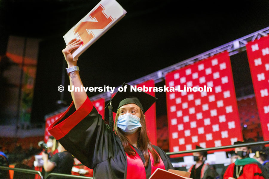 Sara Troyer shows off her CEHS Nebraska diploma to friends and family in the arena. Undergraduate Commencement at Pinnacle Bank Arena. December 18, 2021. Photo by Craig Chandler / University Communication.