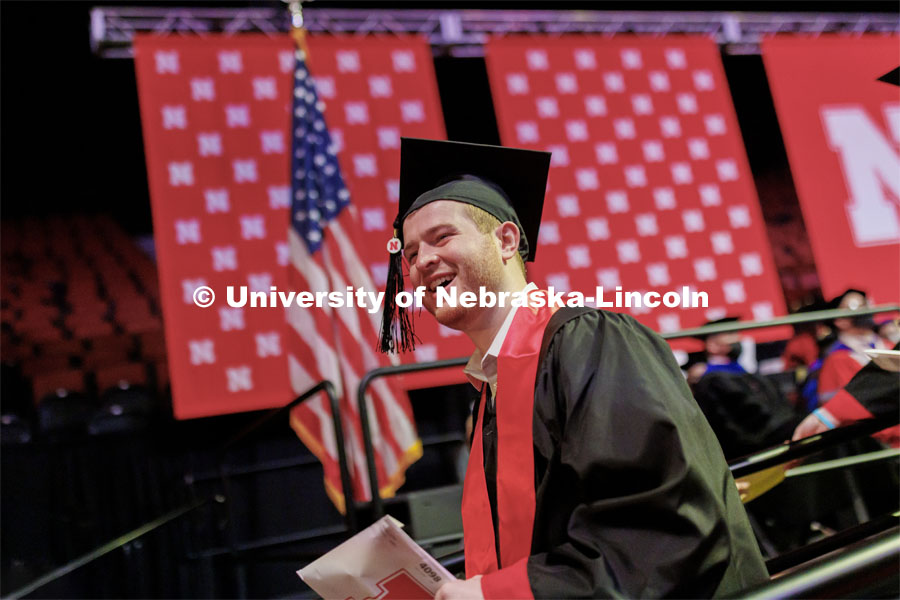 Gabe Luedke smiles as he walks off stage after receiving his CoB diploma. Undergraduate Commencement at Pinnacle Bank Arena. December 18, 2021. Photo by Craig Chandler / University Communication.