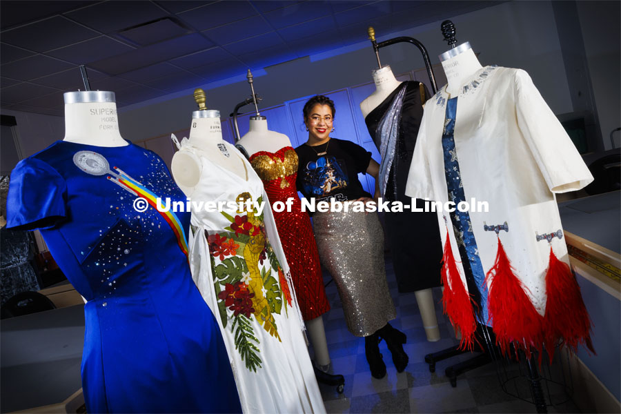 Adria Sanchez-Chaidez, a graduate student in Textiles, Merchandising and Fashion Design, poses with her geek couture designs which feature imagery from (starting at left) Star Trek, Jurassic Park, Wonder Woman, and Star Wars.. From left is Boldly Go, Destination Isla Nublar, Diana on the Town, The Holdo Manuever and Rebellion Reborn. January 21, 2022. Photo by Craig Chandler / University Communication.