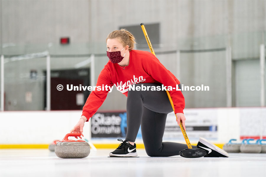 Olivia Schuster serves a curling stone during practice at the John Breslow Ice Hockey Center. Curling Club. February 1, 2022. Photo by Jordan Opp for University Communication.