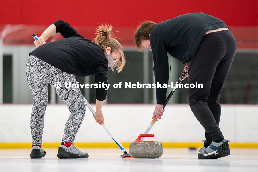Emma Whaley (left) and Seamus Hurley (right) during curling practice at the John Breslow Ice Hockey Center. Curling Club. February 1, 2022. Photo by Jordan Opp for University Communication.