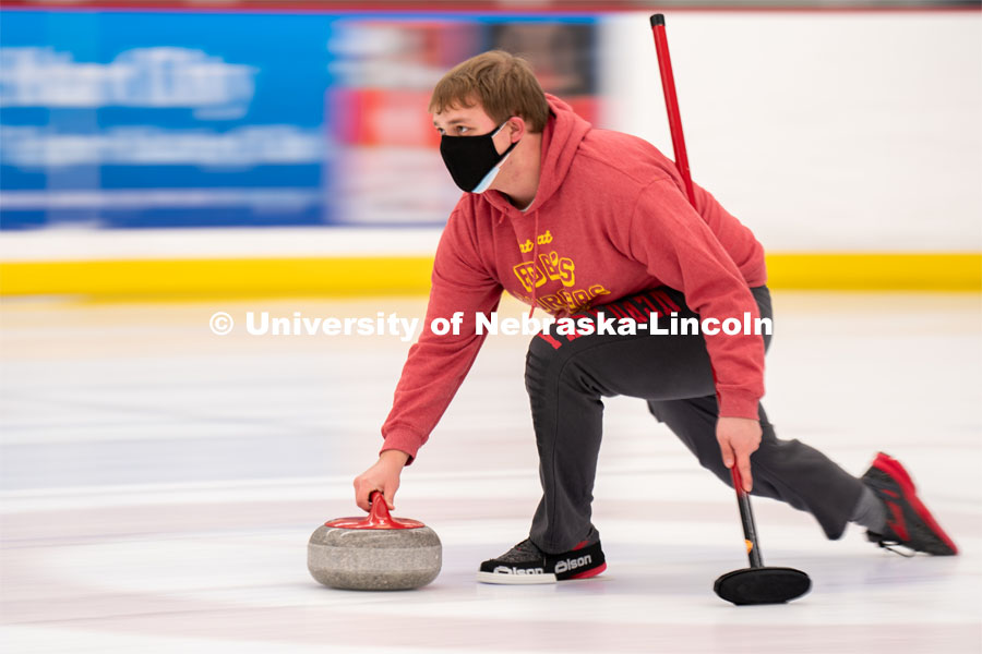 Luke Schroeder serves during curling practice at the John Breslow Ice Hockey Center. Curling Club. February 1, 2022. Photo by Jordan Opp for University Communication.