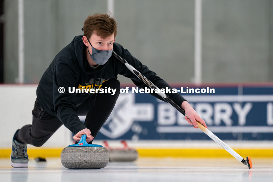 Seamus Hurley serves during curling practice at the John Breslow Ice Hockey Center. Curling Club. February 1, 2022. Photo by Jordan Opp for University Communication.