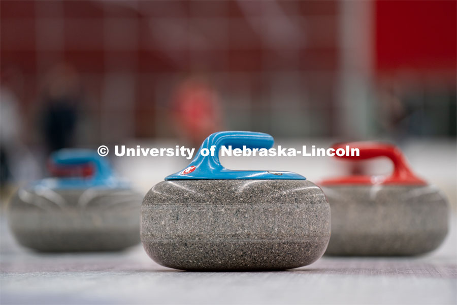 Three curling stones sit on the ice at the John Breslow Ice Hockey Center. Curling Club. February 1, 2022. Photo by Jordan Opp for University Communication.