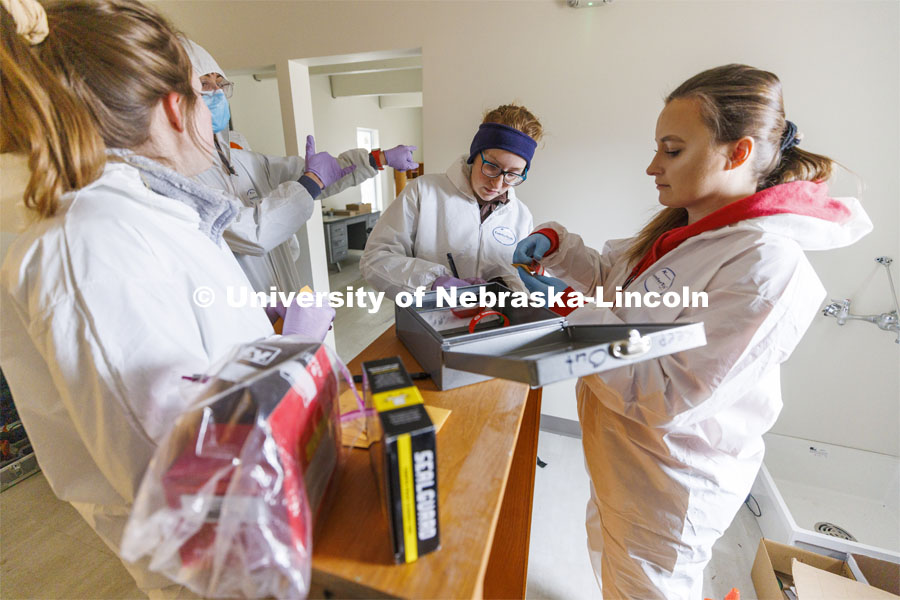 Brandy Branscom, center, and Mariya Dudin log in evidence at the crime scene. Students do crime scene investigation in the murder house. Forensic Science “Murder House” is a small derelict house on the north side of East Campus that has been rebuilt and made accessible for students to use as a location forensic lab. February 17, 2022. Photo by Craig Chandler / University Communication.