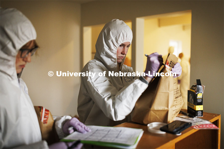 Mariah Kaup seals evidence into a bag so it can be analyzed. Students do crime scene investigation in the murder house. Forensic Science “Murder House” is a small derelict house on the north side of East Campus that has been rebuilt and made accessible for students to use as a location forensic lab. February 17, 2022. Photo by Craig Chandler / University Communication.