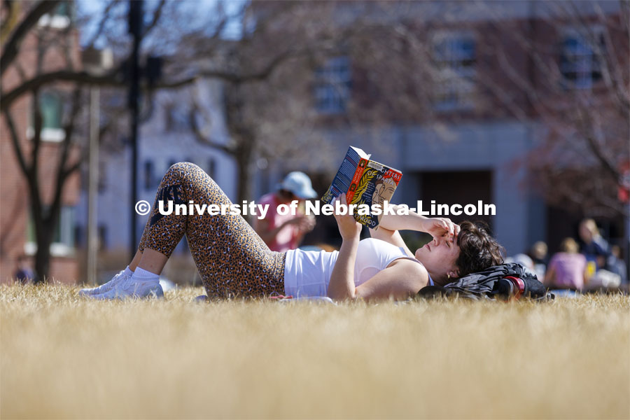 Shelby Serritella, a freshman from Bristol, Wisconsin, catches up on her reading in the greenspace outside the Nebraska Union. Spring on city campus. March 1, 2022. Photo by Craig Chandler / University Communication.