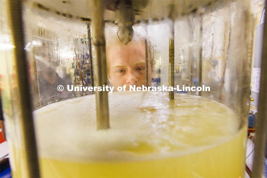 Josiah Kolar examines a bioreactor in Hunter Flodman’s UO Lab. College of Engineering photo shoot. March 22, 2022. Photo by Craig Chandler / University Communication.