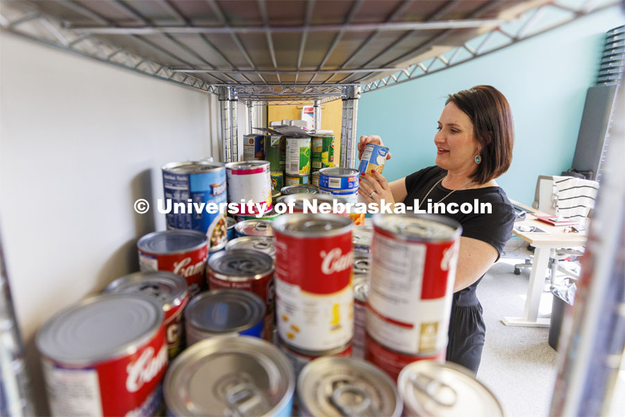 Emily Griffin Overocker, Fine and Performing Arts' Student Success Coordinator, arranges the shelves in the new pop-in pantry in the Hixson-Lied Student Success Center. The center in the Woods Art Building opens Thursday March 24. March 21, 2022. Photo by Craig Chandler / University Communication.