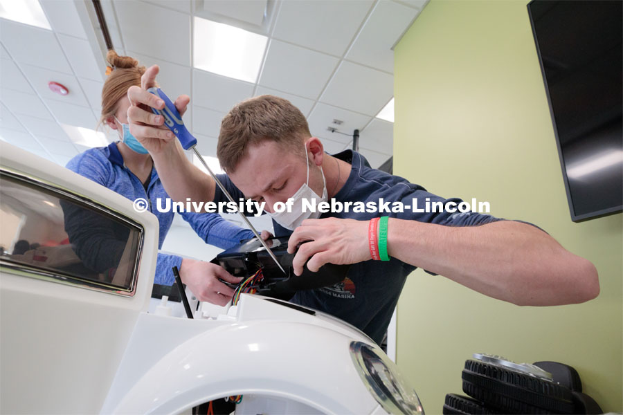 Ethan Bowles, a senior biological systems engineering major, makes an adjustment to the steering wheel in an electric car during the GoBabyGo! Build. His team is modifying the car for four-year-old Dayana Torres of Omaha. Bowles was among seven Huskers to assist with the project. This was his third time volunteering for the event.Twice yearly, Nebraska’s Go Baby Go chapter modifies kid-sized battery powered cars for children with movement difficulties, providing them at no cost to the families. Nebraska’s GoBabyGo! chapter is funded by the Munroe-Meyer Guild. The program is a partnership between MMI's Department of Physical Therapy, the University of Nebraska-Lincoln and the University of Nebraska-Omaha Engineering Department and the UNMC College of Allied Health Professions/Physical Therapy students. The event took place on at the MMI building at 69th and Pine Streets in Omaha on Saturday, April 2, 2022. Photo by Kent Sievers / University of Nebraska Medicine.
