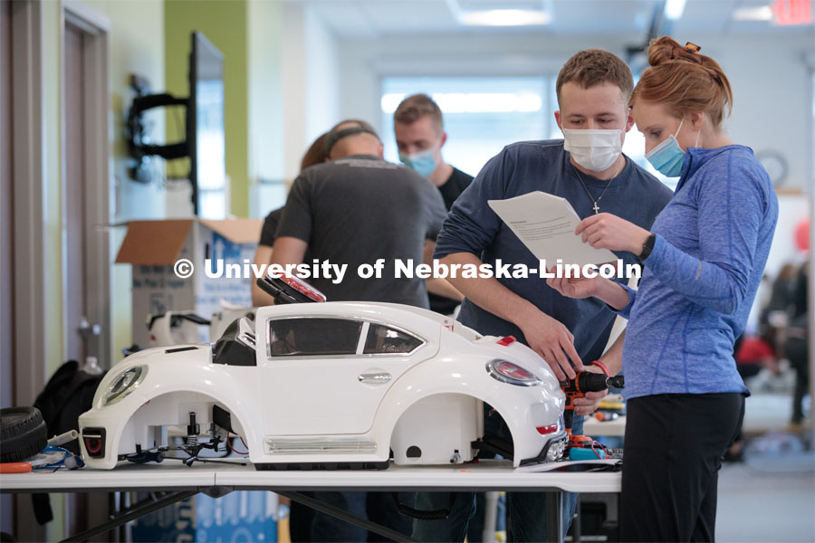 UNL engineering student Ethan Bowles, right, and UNMC physical therapy student Jaime Troester modify a battery-powered car for four-year-old Dayana Torres of Omaha.Twice yearly, Nebraska’s Go Baby Go chapter modifies kid-sized battery powered cars for children with movement difficulties, providing them at no cost to the families. Nebraska’s GoBabyGo! chapter is funded by the Munroe-Meyer Guild. The program is a partnership between MMI's Department of Physical Therapy, the University of Nebraska-Lincoln and the University of Nebraska-Omaha Engineering Department and the UNMC College of Allied Health Professions/Physical Therapy students. The event took place on at the MMI building at 69th and Pine Streets in Omaha on Saturday, April 2, 2022. Photo by Kent Sievers / University of Nebraska Medicine.