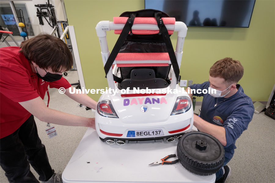 UNL engineering student Ethan Bowles, right modifies a battery-powered car for four-year-old Dayana Torres of Omaha. Twice yearly, Nebraska’s Go Baby Go chapter modifies kid-sized battery powered cars for children with movement difficulties, providing them at no cost to the families. Nebraska’s GoBabyGo! chapter is funded by the Munroe-Meyer Guild. The program is a partnership between MMI's Department of Physical Therapy, the University of Nebraska-Lincoln and the University of Nebraska-Omaha Engineering Department and the UNMC College of Allied Health Professions/Physical Therapy students. The event took place on at the MMI building at 69th and Pine Streets in Omaha on Saturday, April 2, 2022. Photo by Kent Sievers / University of Nebraska Medicine.