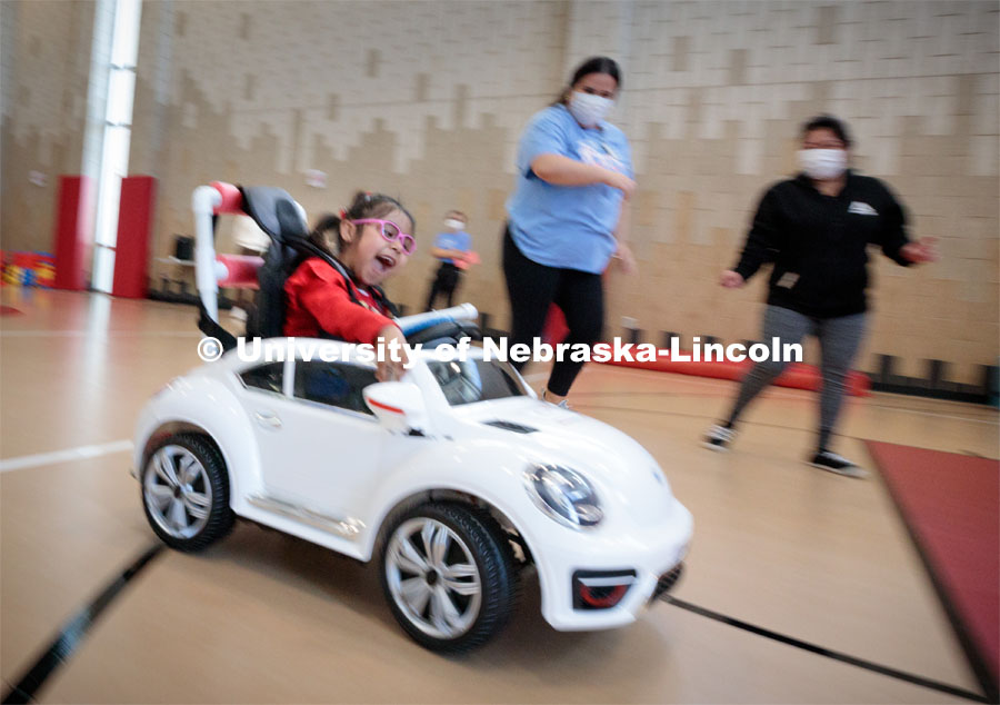 Four-year-old Dayana Torres enjoys the new, battery-powered car that UNL and UNMC students modified for her. Bowles was part of the team that modified the car for Torres.Twice yearly, Nebraska’s Go Baby Go chapter modifies kid-sized battery powered cars for children with movement difficulties, providing them at no cost to the families. Nebraska’s GoBabyGo! chapter is funded by the Munroe-Meyer Guild. The program is a partnership between MMI's Department of Physical Therapy, the University of Nebraska-Lincoln and the University of Nebraska-Omaha Engineering Department and the UNMC College of Allied Health Professions/Physical Therapy students. The event took place on at the MMI building at 69th and Pine Streets in Omaha on Saturday, April 2, 2022. Photo by Kent Sievers / University of Nebraska Medicine.