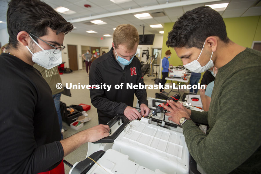 University of Nebraska students (from left) Ricardo Gato Gil, Chandler Brock and Eduardo Mendoza solder wires together as they modify the gas pedal in a GoBabyGo! car. Twice yearly, Nebraska’s Go Baby Go chapter modifies kid-sized battery powered cars for children with movement difficulties, providing them at no cost to the families. Nebraska’s GoBabyGo! chapter is funded by the Munroe-Meyer Guild. The program is a partnership between MMI's Department of Physical Therapy, the University of Nebraska-Lincoln and the University of Nebraska-Omaha Engineering Department and the UNMC College of Allied Health Professions/Physical Therapy students. The event took place on at the MMI building at 69th and Pine Streets in Omaha on Saturday, April 2, 2022. Photo by Kent Sievers / University of Nebraska Medicine.