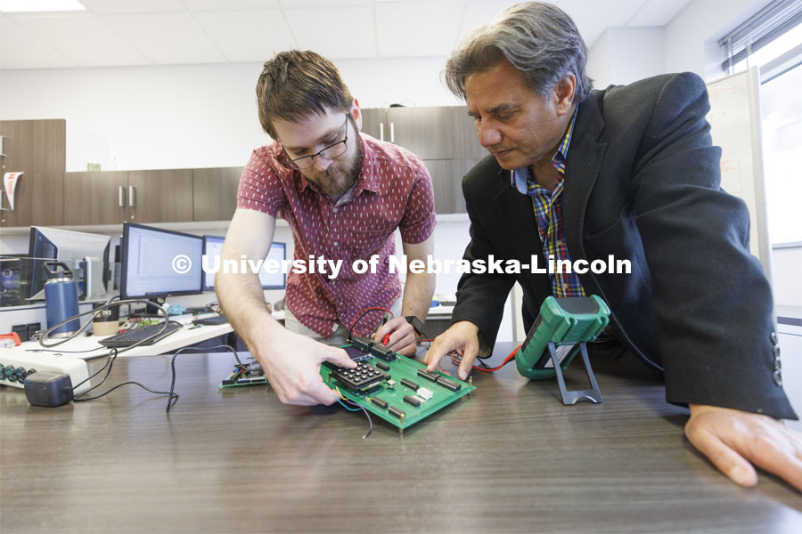 Matthew Boeding and Hamid Sherif test a board in Hamid Sherif’s Telecom lab. College of Engineering photo shoot at Peter Kiewit Institute in Omaha. April 5, 2022. Photo by Craig Chandler / University Communication.