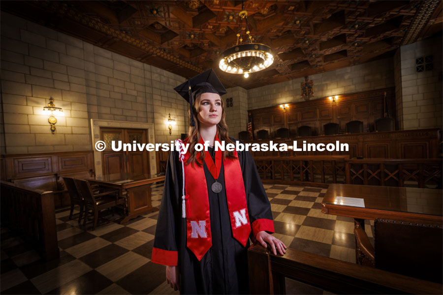 Ashton Koch, of Omaha, will graduate May 14 and attend the University of Nebraska College of Law in the fall and specialize as an immigration lawyer. She is photographed in the Nebraska Supreme Court wearing her graduation regalia. April 26, 2022. Photo by Craig Chandler / University Communication.