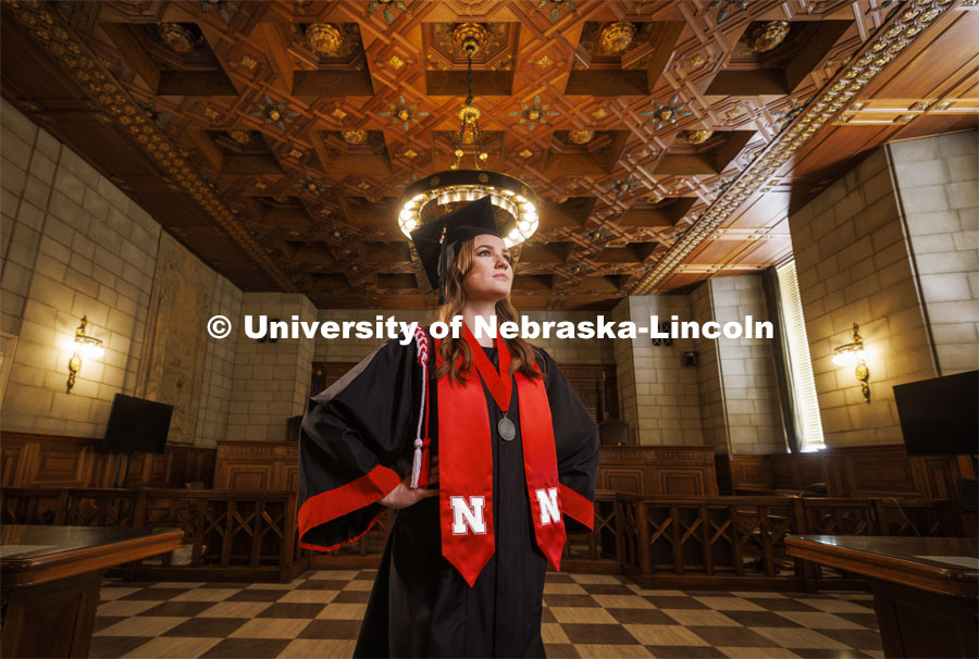 Ashton Koch, of Omaha, will graduate May 14 and attend the University of Nebraska College of Law in the fall and specialize as an immigration lawyer. She is photographed in the Nebraska Supreme Court wearing her graduation regalia. April 26, 2022. Photo by Craig Chandler / University Communication.
