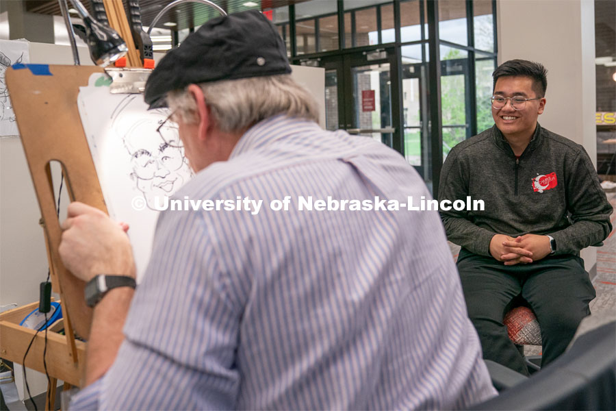 A caricature artist draws students during the End of Year Bash inside the East Campus Union on Saturday, April 30, 2022, in Lincoln, Nebraska.  Photo by Jordan Opp for University Communication