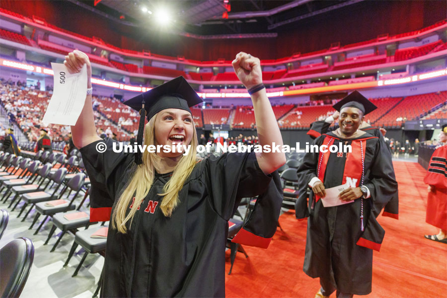 Arlynn Graham gestures to family and friends as she enters the arena. Graduate commencement in Pinnacle Bank Arena. May 13, 2022. Photo by Craig Chandler / University Communication.