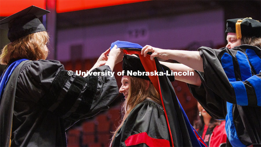 Kylin Flothe’s doctoral hood is lowered into place. Graduate commencement in Pinnacle Bank Arena. May 13, 2022. Photo by Craig Chandler / University Communication.