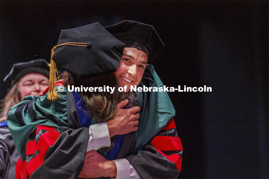 Nicholas Harp hugs Maital Neta after receiving his doctoral degree. Graduate commencement in Pinnacle Bank Arena. May 13, 2022. Photo by Craig Chandler / University Communication.