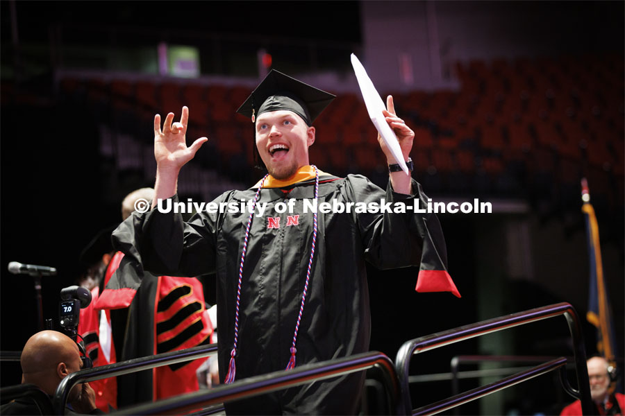 Sheldon Brummel gestures to family after receiving his masters degree. Graduate commencement in Pinnacle Bank Arena. May 13, 2022. Photo by Craig Chandler / University Communication.