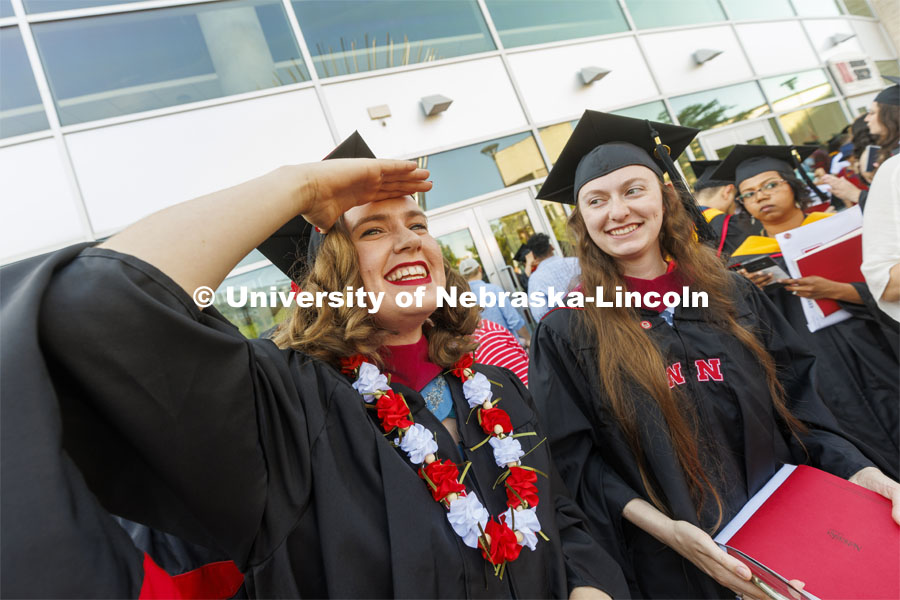 Anna Kuhlman looks for her family outside Pinnacle Bank Arena following commencement. Graduate commencement in Pinnacle Bank Arena. May 13, 2022. Photo by Craig Chandler / University Communication.