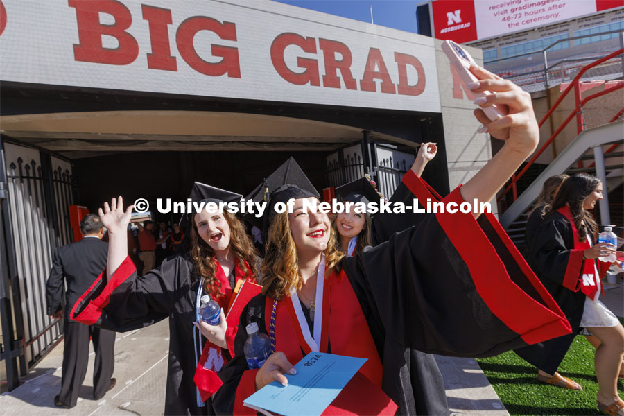 Jenica Ross takes a selfie with friends Samantha Towne, left, and Keisha Widjaja as they enter Memorial Stadium. UNL undergraduate commencement in Memorial Stadium. May 14, 2022.  Photo by Craig Chandler / University Communication.