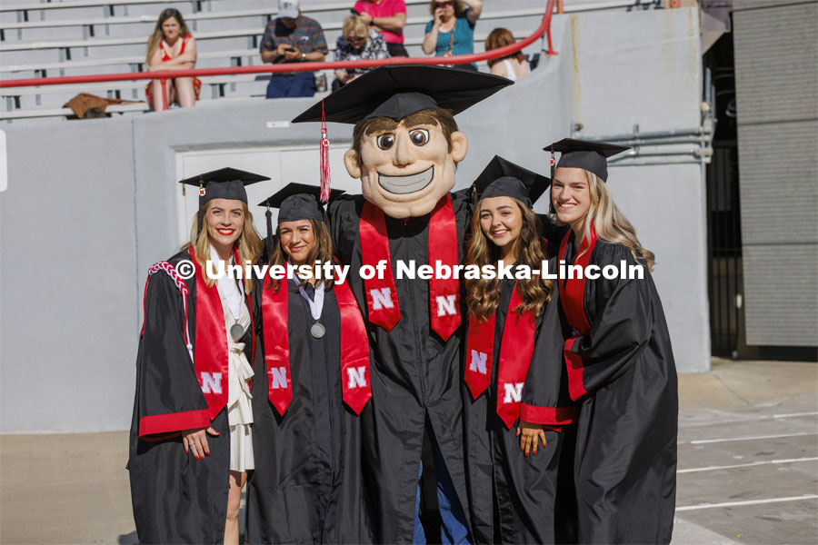 Students pose with Herbie Husker before commencement. UNL undergraduate commencement in Memorial Stadium. May 14, 2022. Photo by Craig Chandler / University Communication.