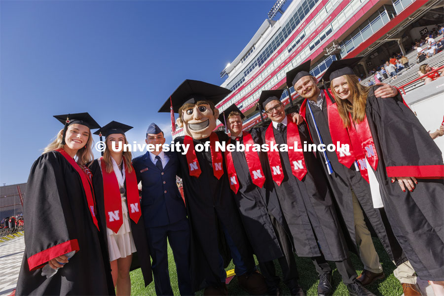 Engineering graduates pose with Herbie Husker before commencement. UNL undergraduate commencement in Memorial Stadium. May 14, 2022. Photo by Craig Chandler / University Communication.