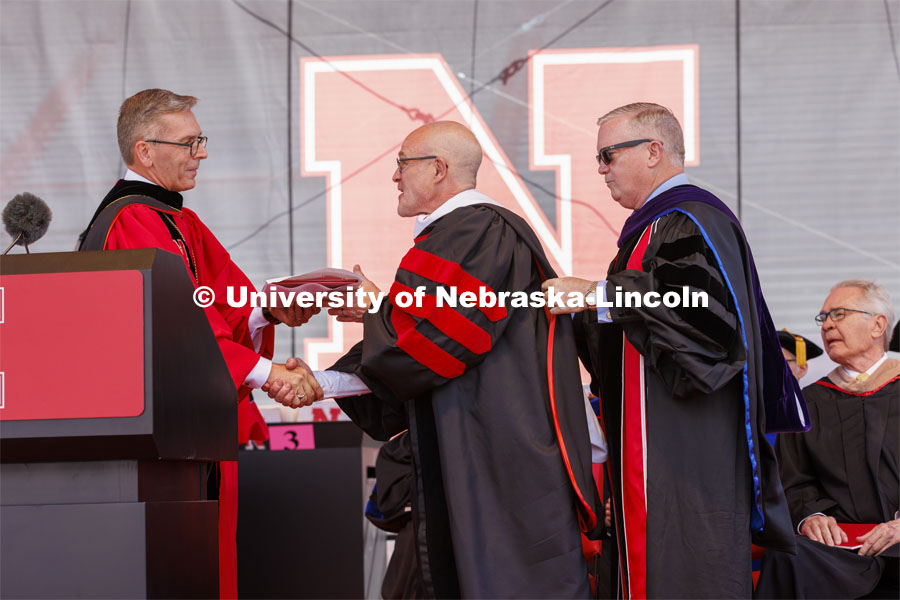 Jay Keasling, a professor of chemical engineering at University of California, Berkeley and a native of Harvard, Nebraska, is awarded an honorary degree by UNL Chancellor Ronnie Green with the assistance of NU Regent Timothy Clare. UNL undergraduate commencement in Memorial Stadium. May 14, 2022. Photo by Craig Chandler / University Communication.