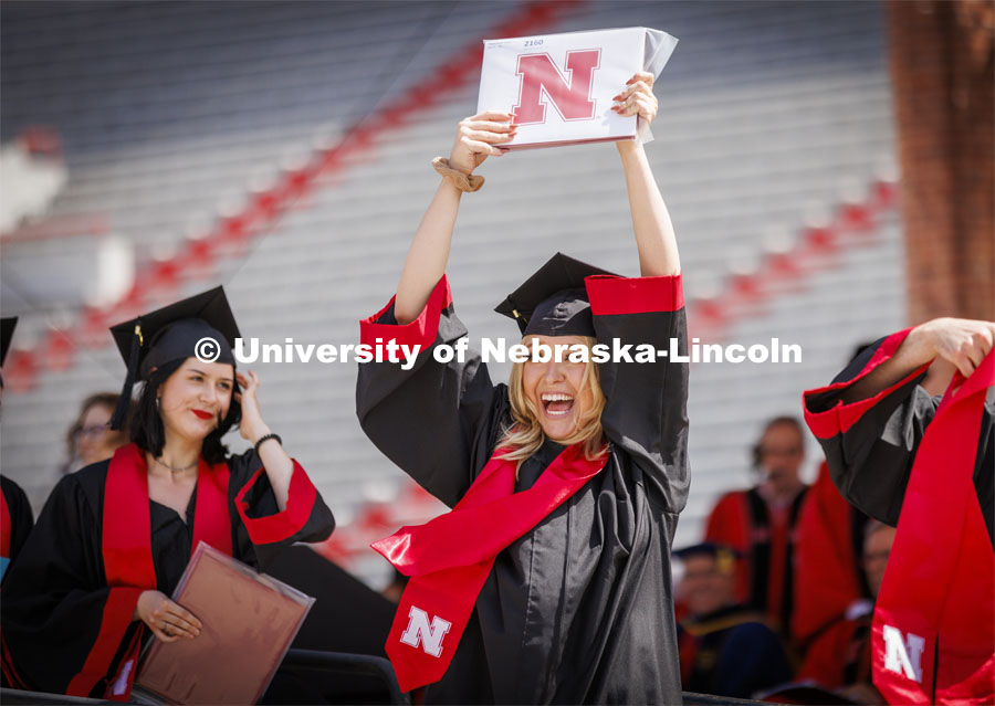 Alayna Verduyn shows off her UNL diploma to friends and family. UNL undergraduate commencement in Memorial Stadium. May 14, 2022. Photo by Craig Chandler / University Communication.
