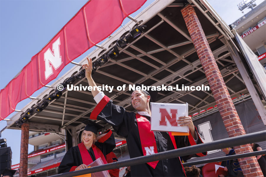 Brett Gaffney waves to his family and friends in Memorial Stadium after receiving his diploma. UNL undergraduate commencement in Memorial Stadium. May 14, 2022. Photo by Craig Chandler / University Communication.