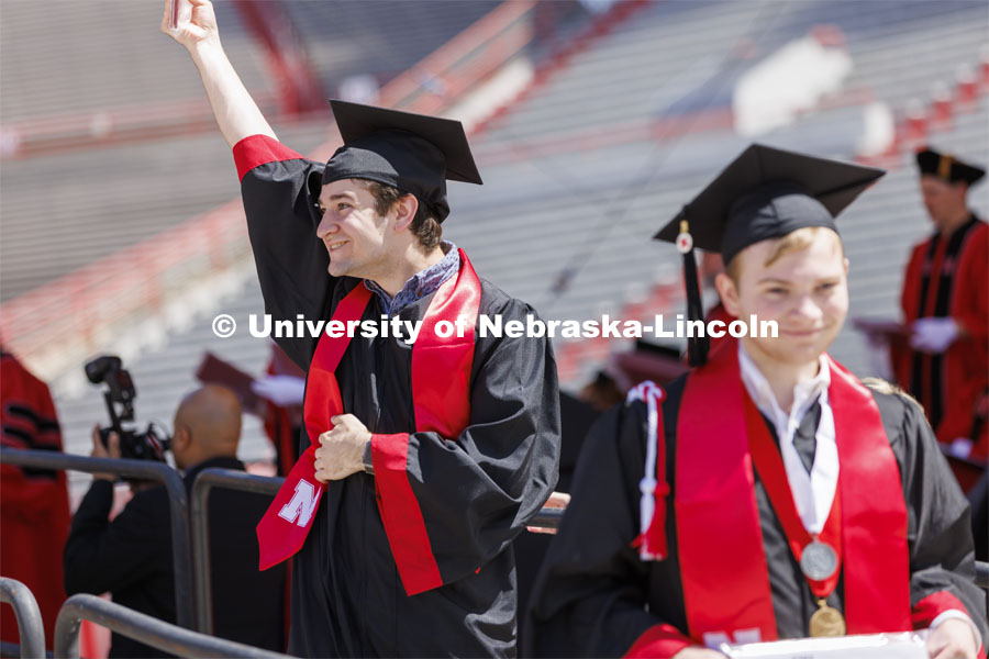 Anthony Wynegar shows off his college of Engineering diploma to friends and family. UNL undergraduate commencement in Memorial Stadium. May 14, 2022. Photo by Craig Chandler / University Communication.