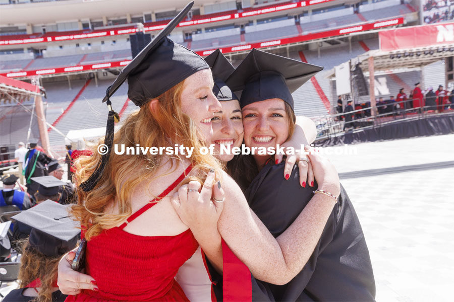 Allison Moore hugs her friends after she received her College of Engineering diploma. UNL undergraduate commencement in Memorial Stadium. May 14, 2022. Photo by Craig Chandler / University Communication.