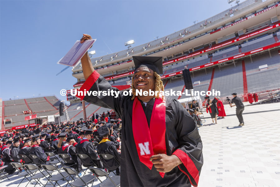 Pheldarius Almon Payne shows off his CEHS diploma to friends and family. UNL undergraduate commencement in Memorial Stadium. May 14, 2022. Photo by Craig Chandler / University Communication.