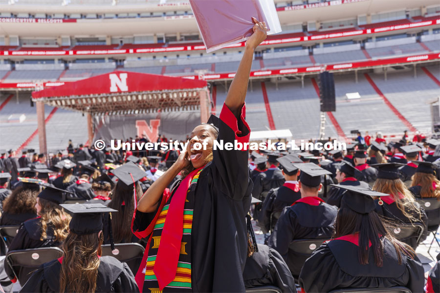 Cherish Perkins, senior in fashion merchandising with minors in international studies, art, and business, waves to her family as she returns to her seat after receiving her diploma. UNL undergraduate commencement in Memorial Stadium. May 14, 2022. Photo by Craig Chandler / University Communication.