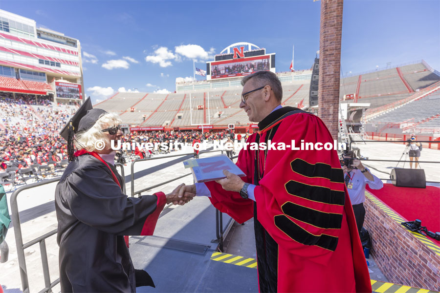 Carol (Dahl Leacox) Livingston receives her diploma from Chancellor Ronnie Green. Livingston finally received her diploma — Bachelor of Science in Business Administration — for her studies at the University of Nebraska-Lincoln from 1955-59. UNL undergraduate commencement in Memorial Stadium. May 14, 2022. Photo by Craig Chandler / University Communication.