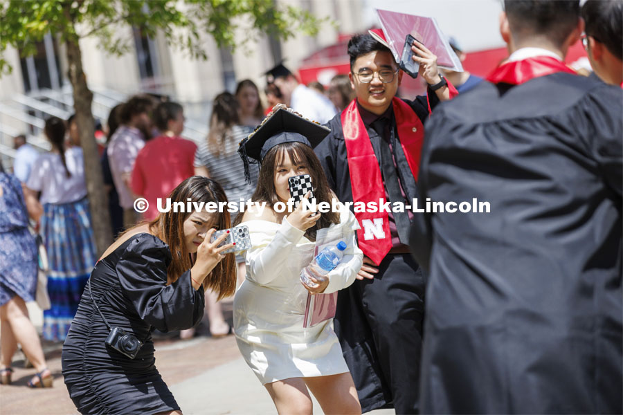 New grads pose for photos with their families. UNL undergraduate commencement in Memorial Stadium. May 14, 2022. Photo by Craig Chandler / University Communication.